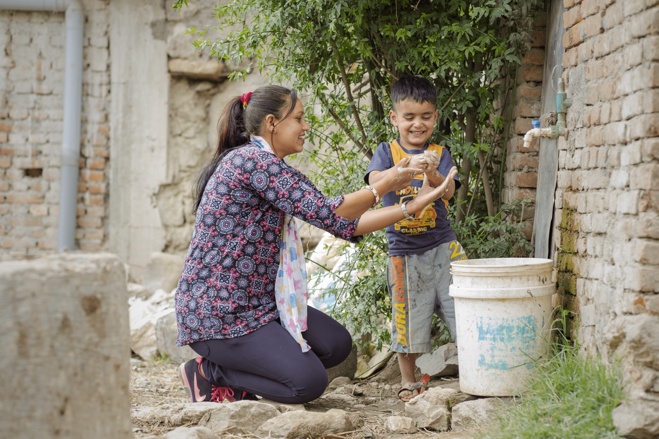 Woman and boy washing hands with soap