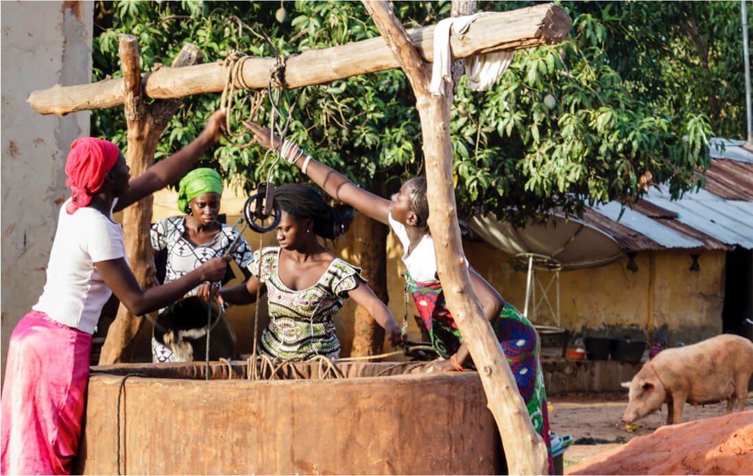 Women taking water out of a well