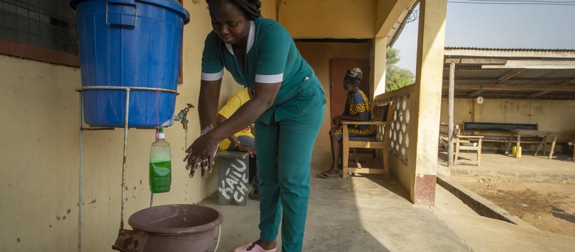 Women washing hands outside with soap